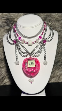 a necklace with a pink heart on it